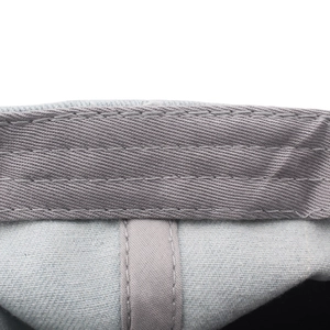 Close-up of internal sweatband stitching on a washed denim baseball cap