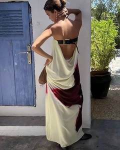 Detail of backless beige maxi dress featuring black leather buckle and red abstract print