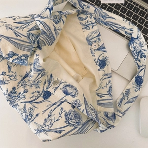 Detail of blue floral porcelain pattern on vintage canvas crossbody bag with magnetic clasp