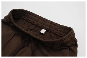 Detail of high elastic waistband on brown joggers with matching flat drawstring cords