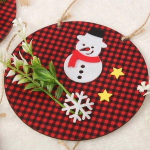 Close-up of Christmas wooden door hanger with felt snowman and buffalo plaid decoration