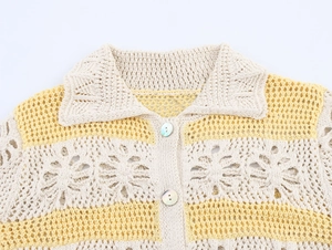 Detailed close-up of yellow floral openwork knit cardigan with shell buttons