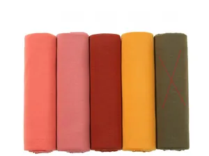 Close-up of jersey turban scarves in coral, pink, yellow and olive green colors