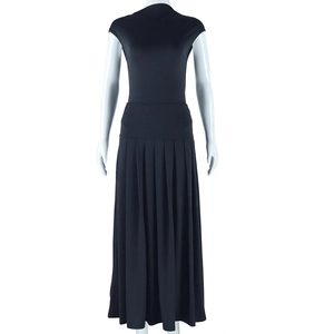 Detail view of the black sleeveless high-neck top and pleated long skirt texture