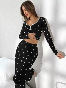 Detail of black rib-knit fabric with white hearts and delicate lace neckline
