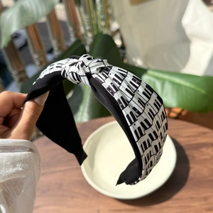 Detail of fabric headband with piano key print and a stylish top knot design