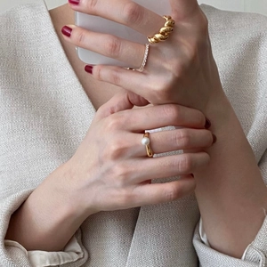 Close-up of S925 silver rings with pearl and twisted textures on a model's hand