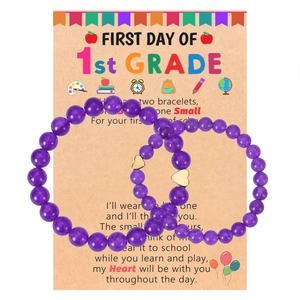 Detail of purple natural stone beads bracelets with golden heart charms on card