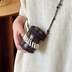 Detail of handmade bohemian coconut shell bag with intricate beadwork and woven texture