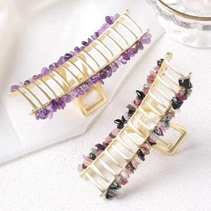 Detail of gold metal hair clips with natural purple and multi-color crystal stones