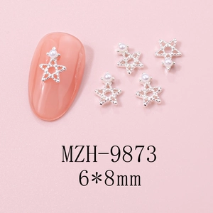 Macro view of star-shaped nail charms with hollow alloy design and inlaid pearls