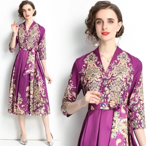 Elegante vestido morado con escote en V, estampado floral dorado y cintura lazada