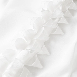 Macro shot of elegant white chiffon fabric featuring delicate ruffled edge detailing