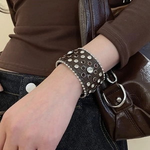 Détail d'un bracelet large en cuir embossé crocodile avec perles argentées et strass