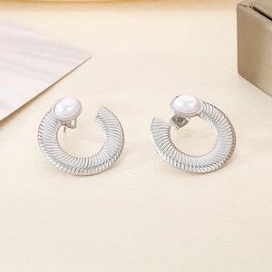 Macro detail of silver U-shaped earrings with spiral texture and white pearl accents