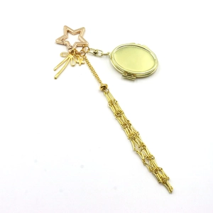 Detail showing golden star-shaped clasp with locket and bow pendant accessory