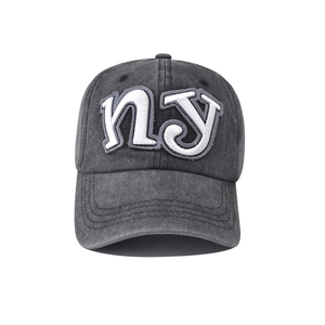 Close-up of white NY 3D embroidery on a dark grey washed cotton baseball cap