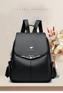 Detail of black lychee leather backpack showing kangaroo logo and metal hardware buckle