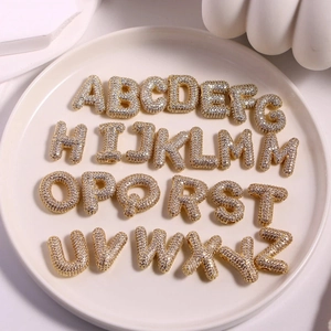 Détail de 26 pendentifs lettres bulles en or 18K sertis de pierres de zircone blanches