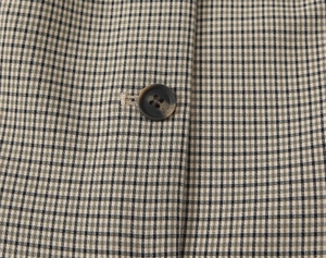 Détail de tissu à carreaux noir et blanc avec un bouton en résine marbrée brune