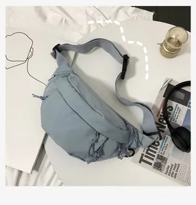 Close-up of Morandi blue nylon chest bag with drawstring details and multi-zipper pockets