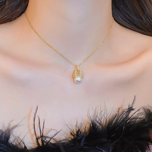 Nahaufnahme einer eleganten 18k vergoldeten Halskette mit Perlenanhänger an einem Model
