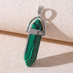 Macro detail of hexagonal green stone pendant with a polished silver metal bail