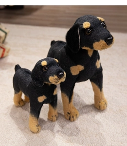 Close-up of realistic black and tan Rottweiler plush set on a soft white carpet