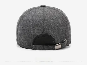 Close-up of the adjustable metal buckle and dark grey wool texture on a winter baseball cap