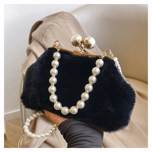 Detail of black plush handbag with elegant pearl handle and metallic closure clasp