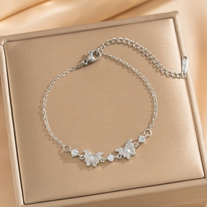 Adjustable silver butterfly bracelet with sparkling zircon stones on a golden display