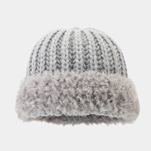 Nahaufnahme von Strickmuster und Teddyfutter an der hellgrauen Winterstrickmütze