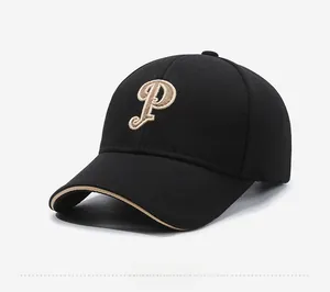 Détail d'une casquette noire avec lettre P brodée dorée et visière structurée
