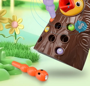 Macro shot showing magnetic bird tool catching colorful worms in a plastic tree stump