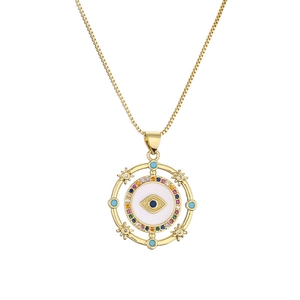 Gold evil eye pendant necklace with colorful zircons and white enamel on white background