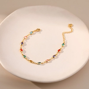 Exotic 18K gold-plated chain bracelet with colorful acrylic gemstones on a ceramic tray