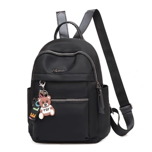 Fashionable black nylon backpack with multi-pocket design and cute bear pendant