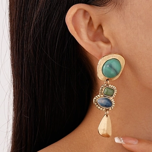 Mannequin portant des boucles d'oreilles vintage dorées avec pierres résine colorées