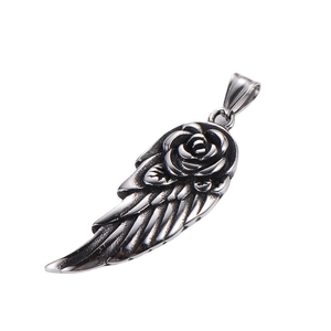 Vintage silver feather wing pendant with central rose flower detail on white background