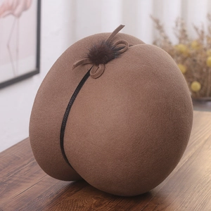 Détail du chapeau cloche en laine marron avec ruban à paillettes et pompon en fourrure