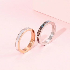 Detail view of Roman letter rings with white shell and abalone shell inlays