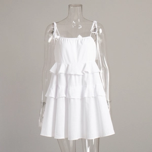 Close-up of tiered ruffle layers and adjustable tie-shoulder straps on white sun dress