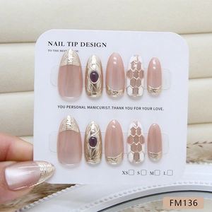 Handmade mauve press-on nails with 3D gold embossed lines and purple gemstone accents