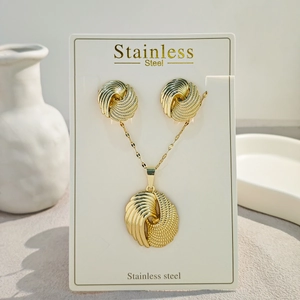 Detail of twisted gold stainless steel jewelry set including earrings and necklace