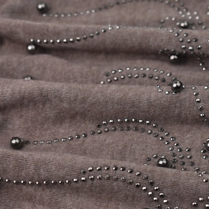 Macro d'un bonnet en tricot marron café avec strass et motifs en perles métalliques