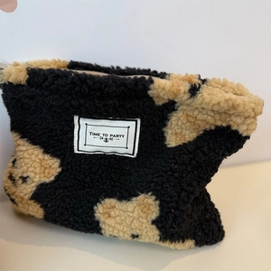 Large capacity plush makeup bag with black and white spotted pattern and zipper closure