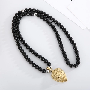 Detail of 8mm black onyx bead necklace with silver spacers and gold lion head pendant