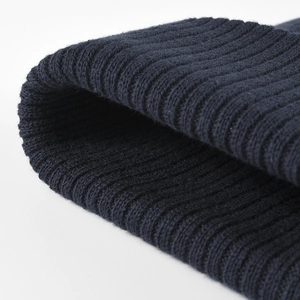 Close-up of a navy blue rib-knit winter beanie showing thick vertical texture and quality weave