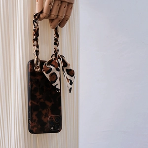 Detail of leopard print phone case with chic braided strap and decorative bow