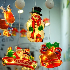 Close-up of warm yellow LED Christmas window lights with reindeer and snowman designs